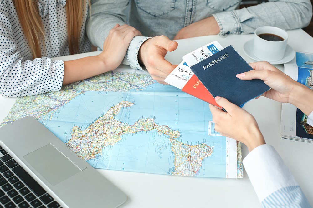 Couple in a tour agency with tickets and passports 