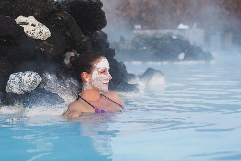 Enjoying the Blue Lagoon warm waters with a healing silica mud mask, Iceland 