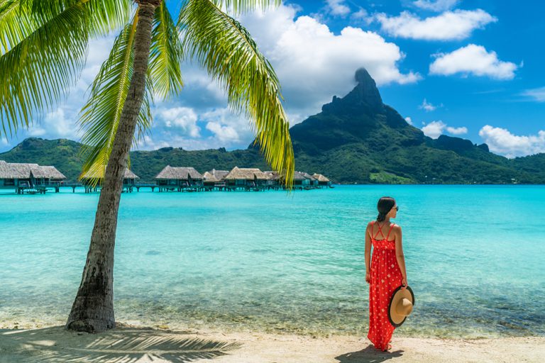 Woman on beach with view of Mt Otemanu in Bora Bora, Tahiti (French Polynesia)