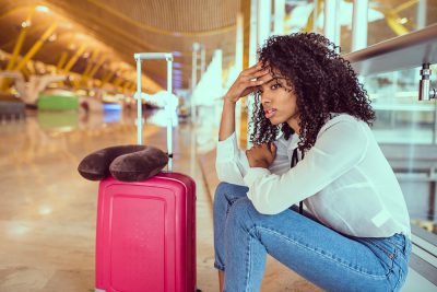 Woman sad and unhappy at the airport with flight cancelled