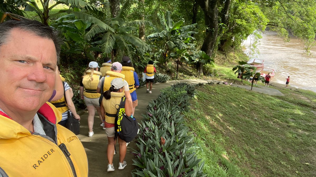 group of people heading to river in tropical environment